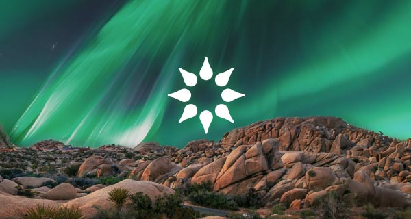 The California Psychics logo (a lotus flower that looks like the sun) over a mountain range. The sky is tinted with green light.